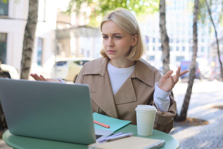Free Photo image of woman with confused face looking at laptop working remotely chatting with someone and