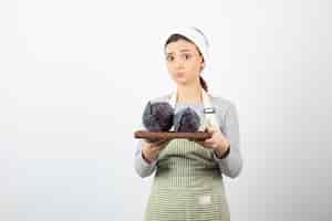 Free photo image of young beautiful housewife holding plate of purple cabbages