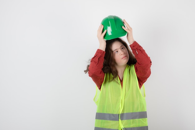 Immagine di una giovane ragazza carina in piedi in giubbotto e indossa un casco.