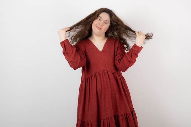 Image of a young cute girl with down syndrome standing and posing .