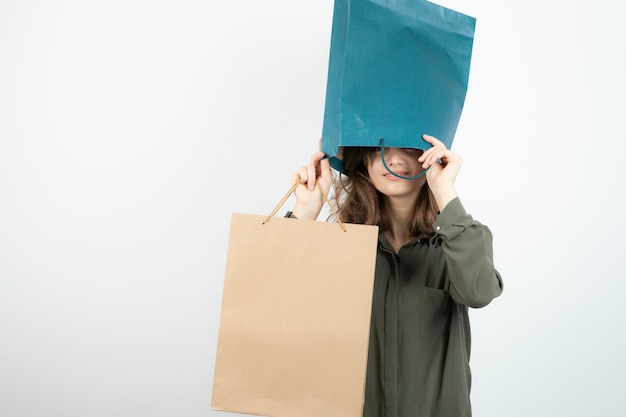 Image of young girl getting her head inside of craft bag. High quality photo
