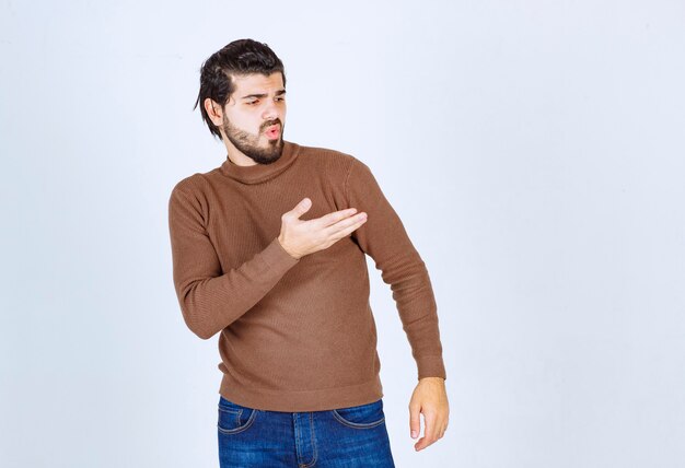 Image of a young handsome man standing and showing away. High quality photo