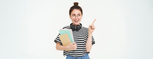 Free photo image of young modern girl student or teacher in glasses holding documents and notebooks pointing at