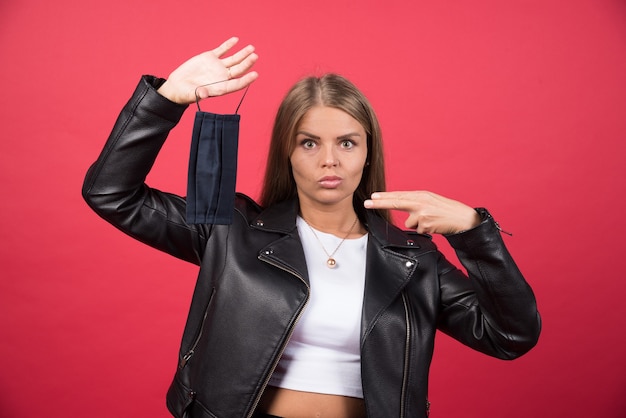 Foto gratuita immagine di una giovane donna che toglie la maschera protettiva