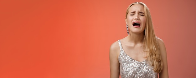 Foto gratuita immaturo piagnucoloso viziato figlia adulta ricca capelli lunghi biondi in abito elegante argento lamentandosi triste