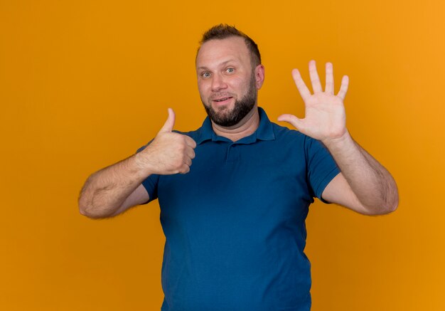 Impressed adult slavic man looking showing six with hands 