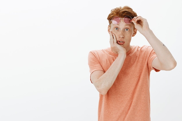 Impressed and amazed redhead man take-off sunglasses