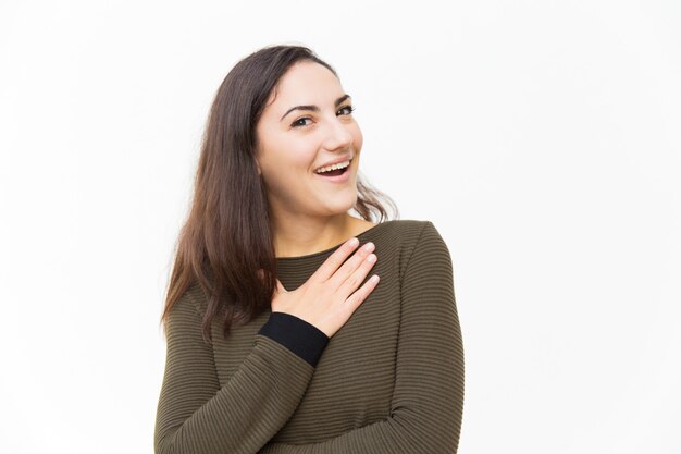 Impressed excited beautiful woman keeping hand on chest