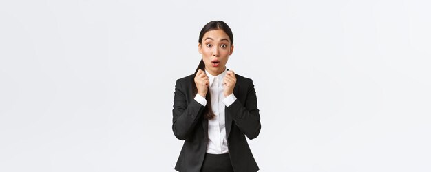 Impressed and excited businesswoman real estate agent hear amazing news widen eyes and say wow in amazement looking surprised and astounded standing in suit over white background