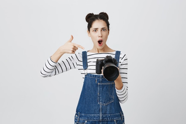 Impressed girl photographer pointing finger at camera display, praise great shots, awesome model work