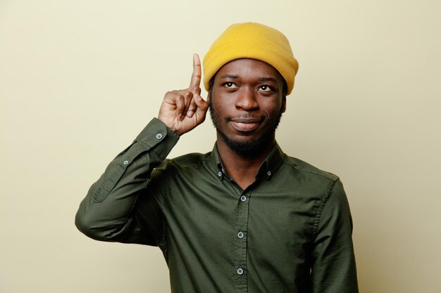 impressed points at up young african american male in hat wearing green shirt isoloated on white background