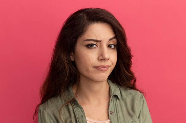 Impressed  young beautiful girl wearing olive green t-shirt isolated on pink wall