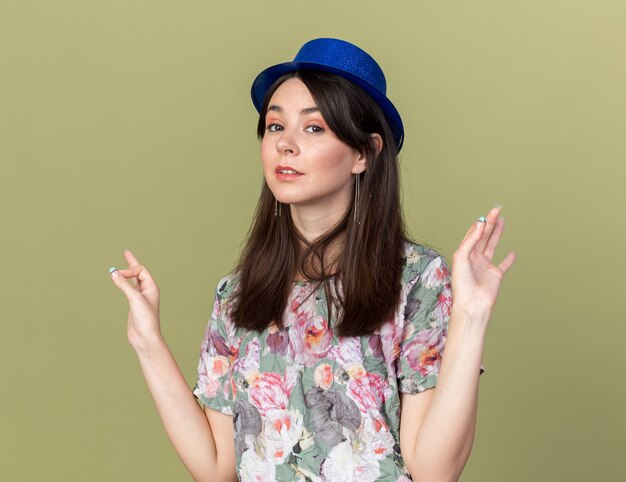 Впечатленная молодая красивая девушка в партийной шляпе, показывающая хороший жест