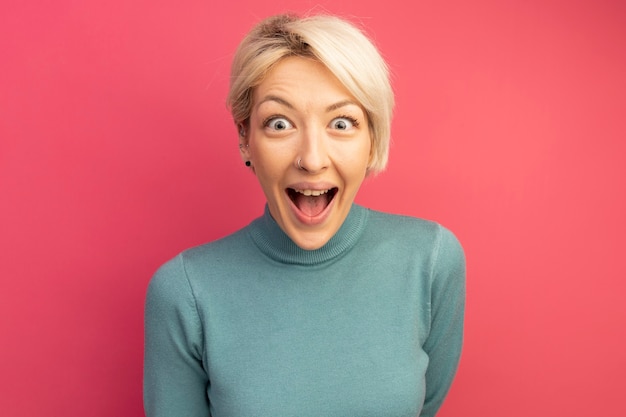 Free photo impressed young blonde girl looking  isolated on pink wall