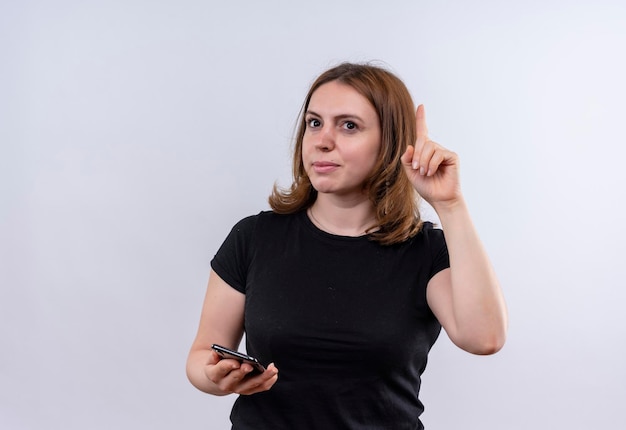 Impressed young casual woman holding mobile phone and raising finger on isolated white space with copy space