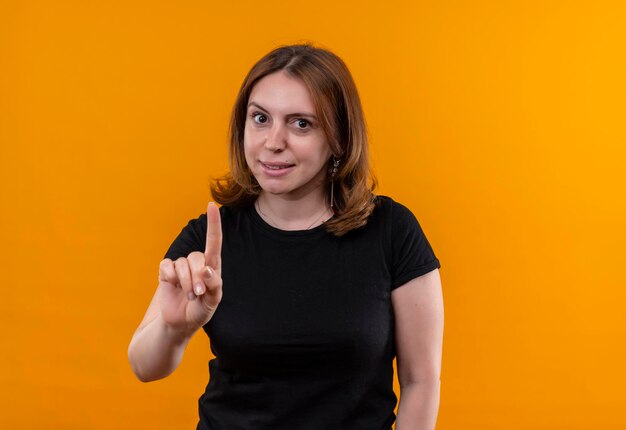 Впечатленная молодая случайная женщина с поднятым пальцем на изолированном оранжевом пространстве с копией пространства