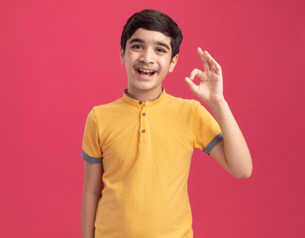 Impressed young caucasian boy doing ok sign 