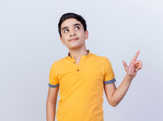 Impressed young caucasian boy looking and pointing at side isolated on white background with copy space
