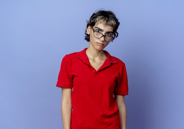 Impressed young caucasian girl with pixie haircut wearing glasses looking at camera isolated on purple background with copy space