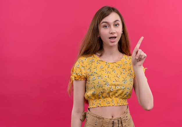 Impressed young girl raising finger on isolated pink space with copy space