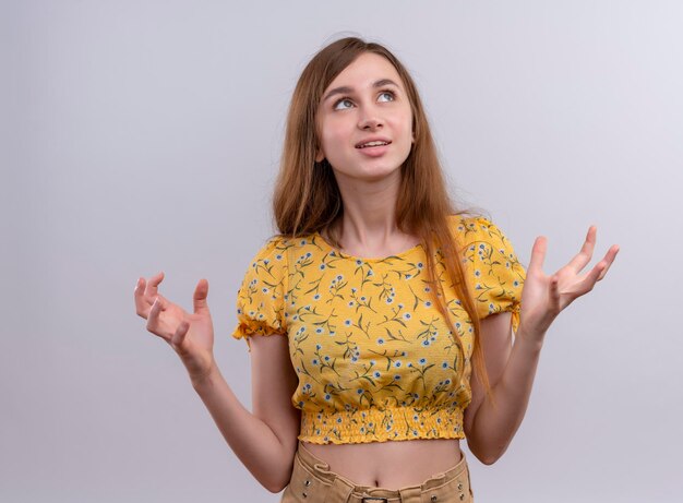 Impressed young girl with raised hands and looking up 