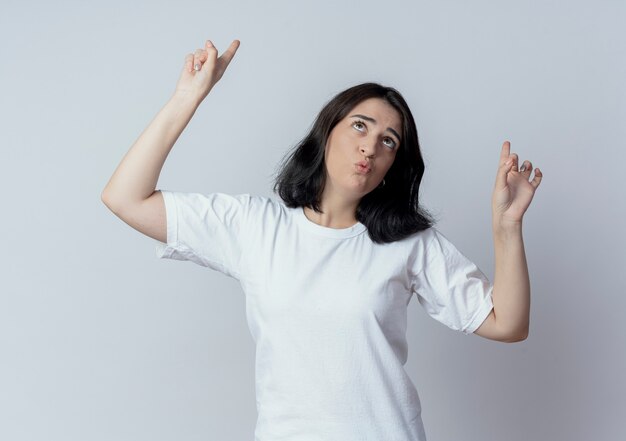 Impressed young pretty caucasian girl looking and pointing up isolated on white background