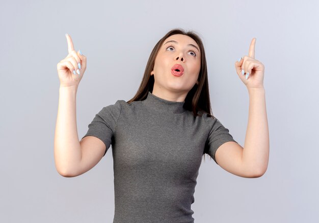 Impressed young pretty woman looking and pointing up isolated on white background