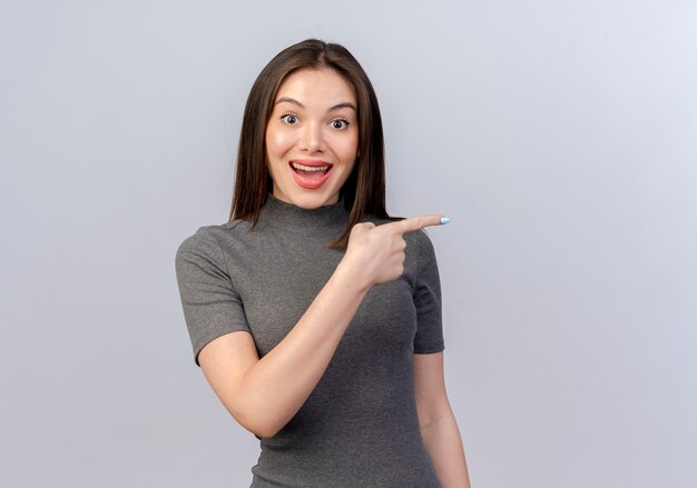 Impressed young pretty woman pointing at side isolated on white background with copy space