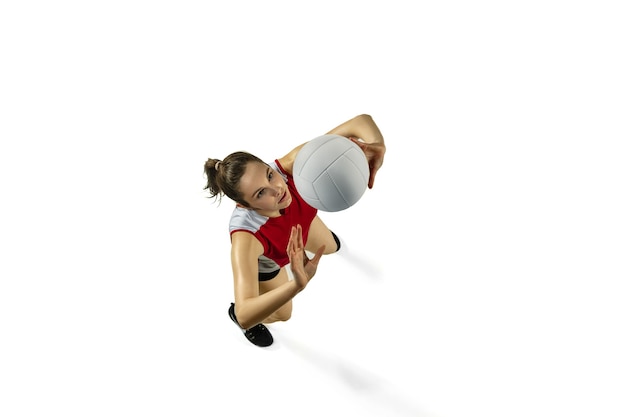 В прыжке и в полете. молодой женский волейболист, изолированные на белом фоне студии. женщина в спортивной одежде и кроссовках тренируется, играет. понятие спорта, здорового образа жизни, движения и движения. Premium Фотографии