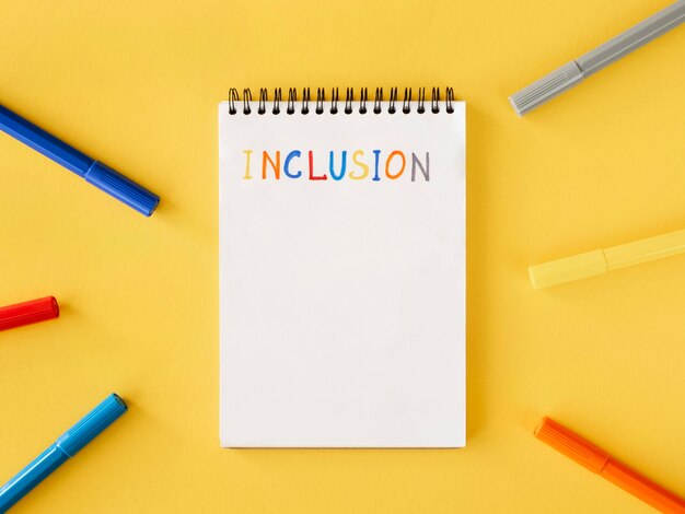 Inclusion word written in a notebook top view