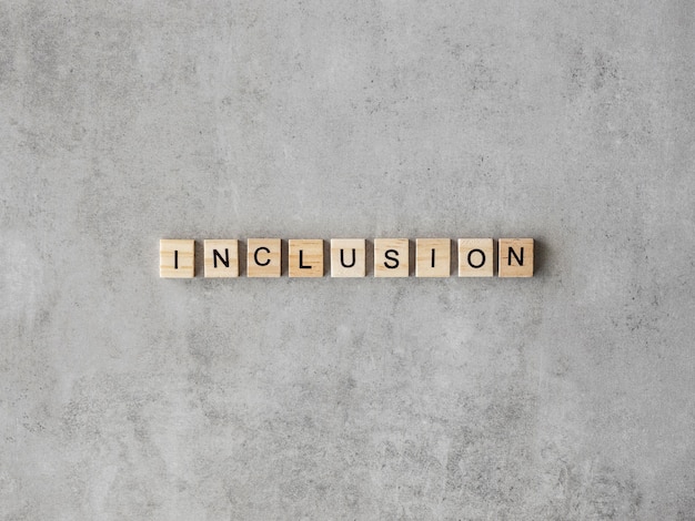 Inclusion word written in scrabble letters on marble background