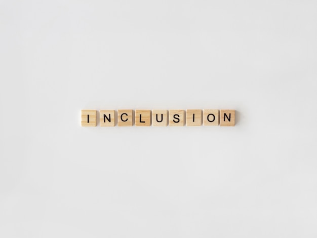 Inclusion word written in scrabble letters on white background