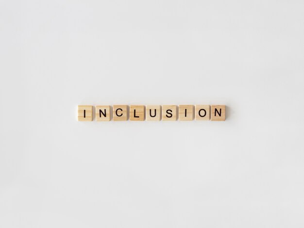 Inclusion word written in scrabble letters on white background