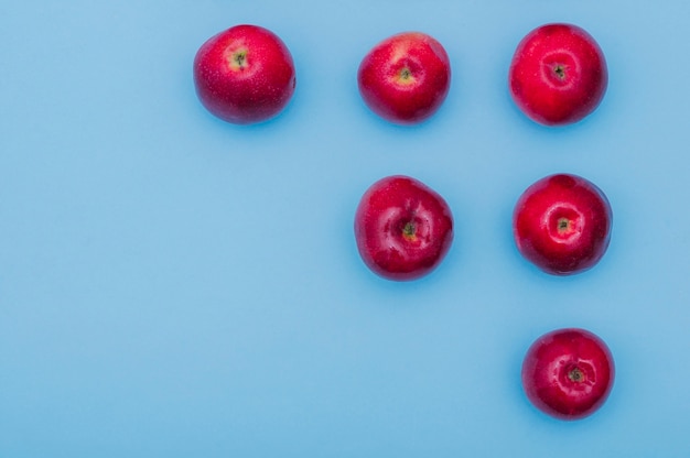 Увеличение ряда красных свежих яблок на синем фоне