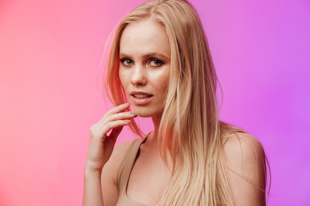 Incredible woman standing and posing over pink wall