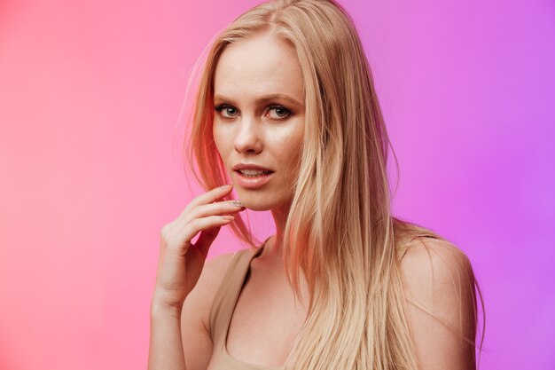 Incredible woman standing and posing over pink wall