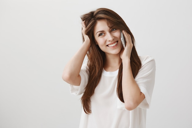 Indecisive cute girl make decision during phone call, thinking and looking left unsure