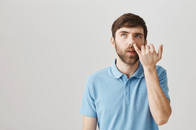 Indecisive young bearded man posing