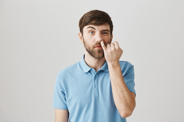 Indecisive young bearded man posing