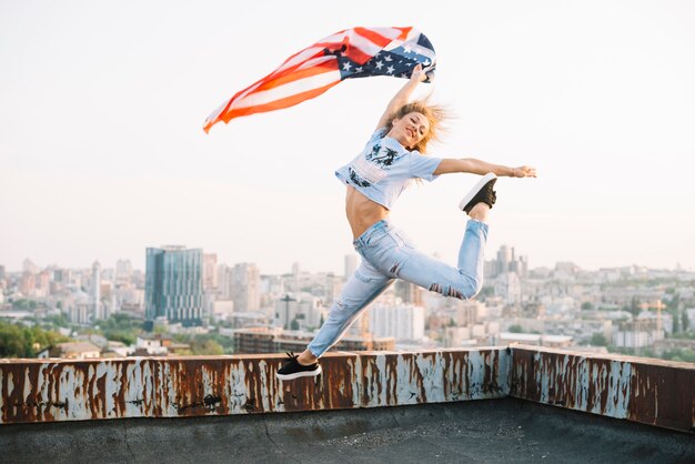 Independence day concept with girl jumping on rooftop 