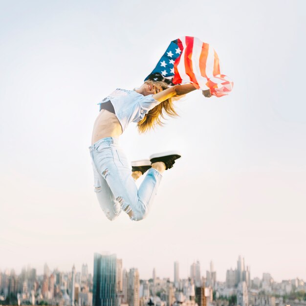 Independence day concept with girl jumping on rooftop