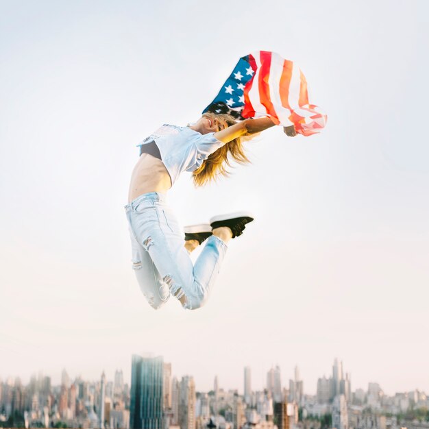 옥상에서 점프하는 소녀와 함께 독립 기념일 개념