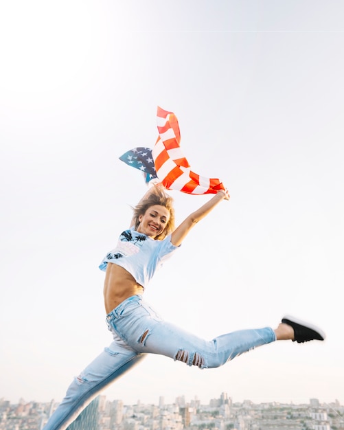 Independence day concept with girl jumping on rooftop