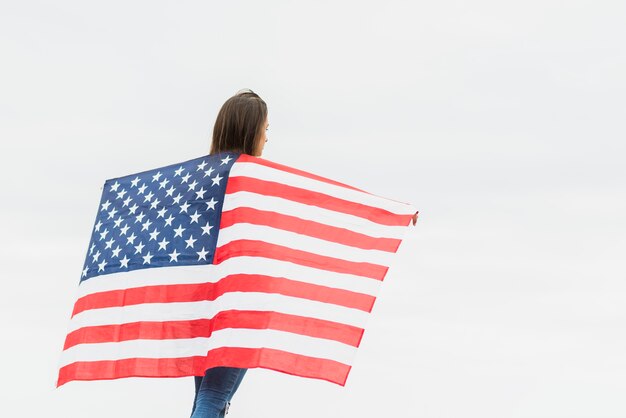 Independence day concept with woman holding flag on sky background