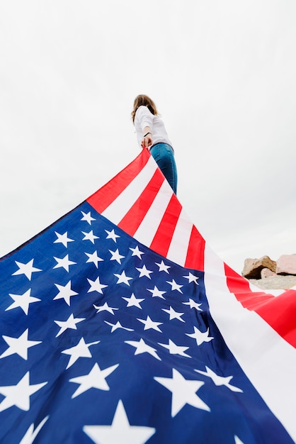 미국 국기를 당기는 여자와 독립 기념일 개념