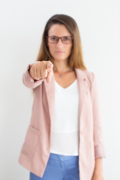 Index finger of businesswoman pointing at camera