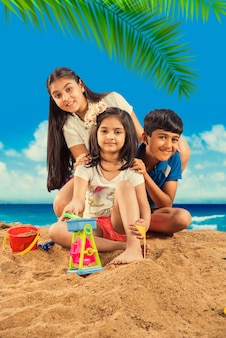 해변 모래에서 노는 인도 아시아 귀여운 아이들