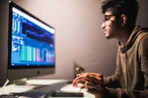 Free photo indian bitcoin trader checking stock trading data analysis concept working in office with financial graph on computer monitors