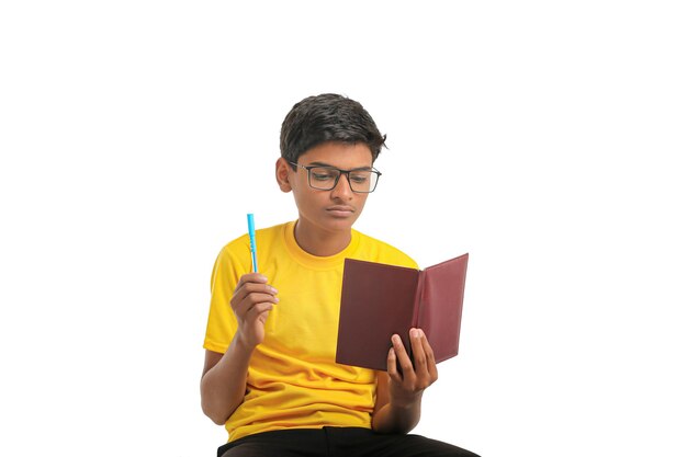 Индийский мальчик держит дневник в руке и думает о какой-то идее на белом фоне.