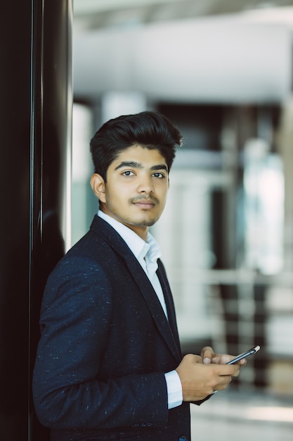 Indian business man reading or using smart phone in office